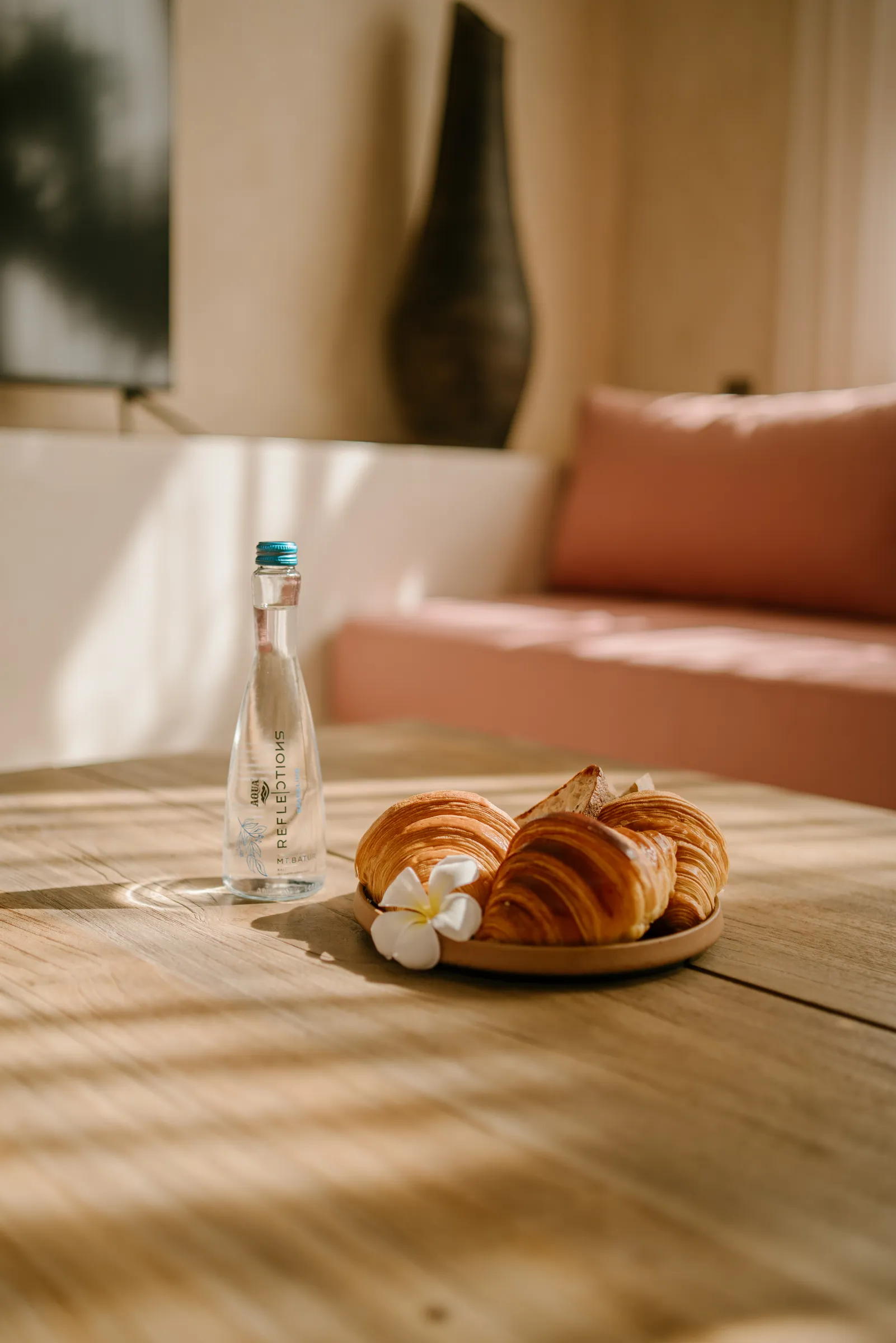 Breakfast tray with water, croissants and a flower