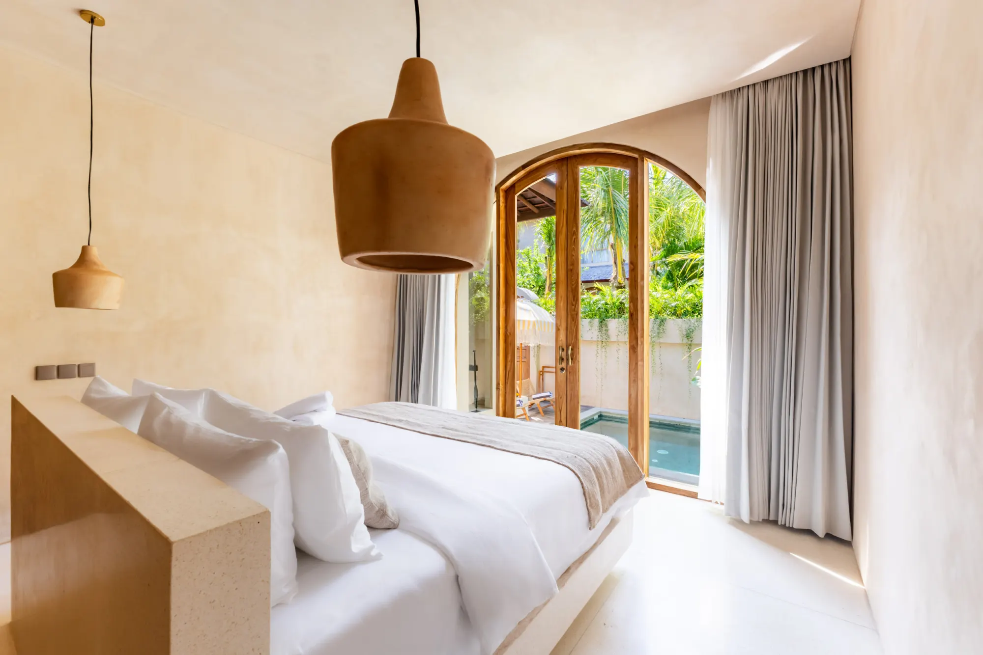 Bedroom with pendants overlooking private pool and courtyard