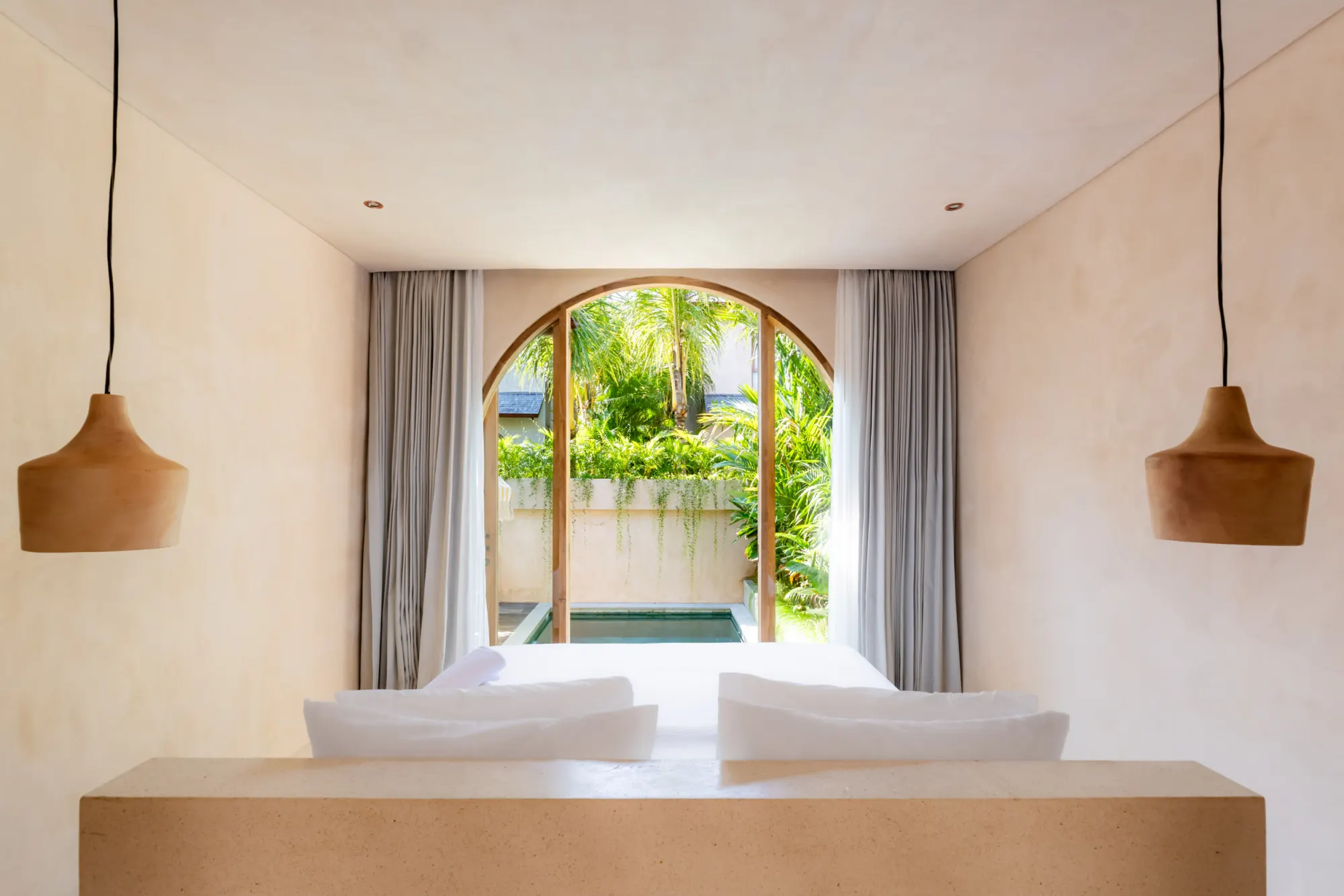 Master bedroom with arched doorway opening to private pool area
