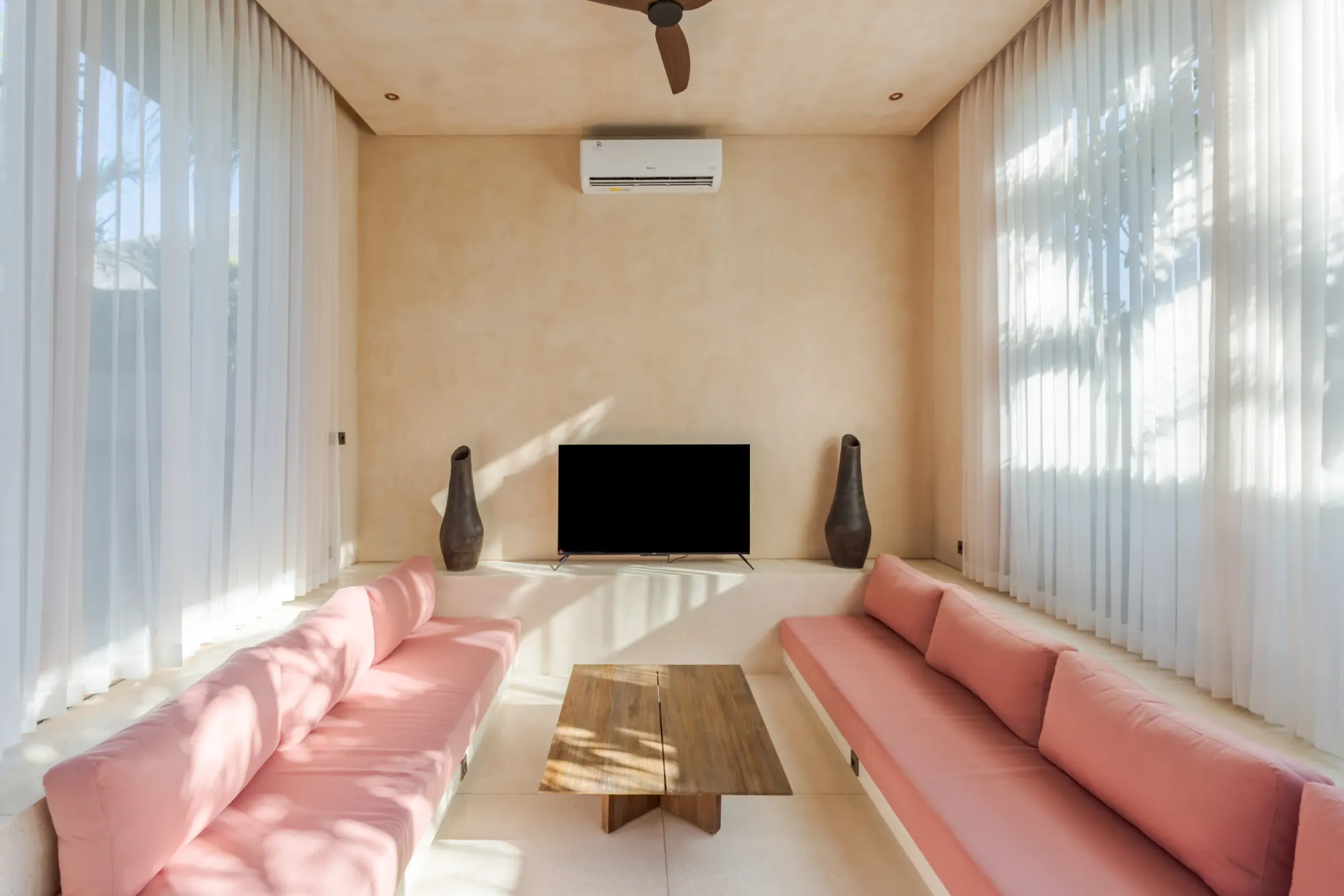 Minimalist living room with pink seating and natural light