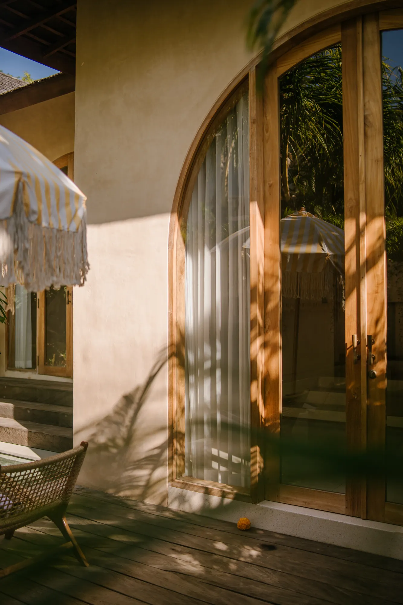Warm sunlit courtyard with wooden sliding doors and plants