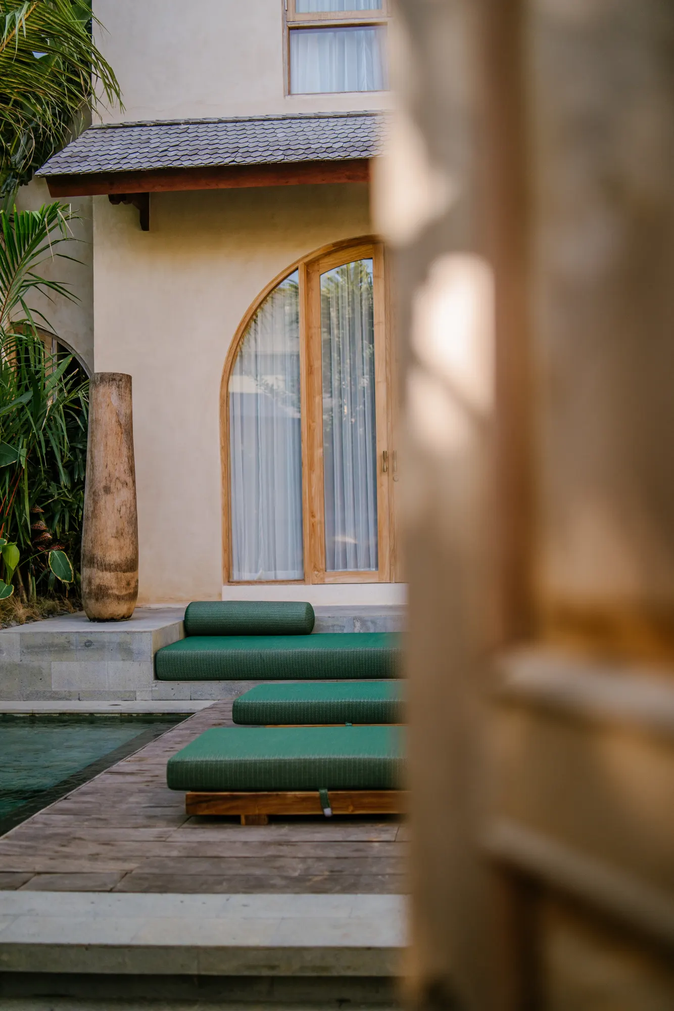Garden view with green rolled textiles and white architectural framing
