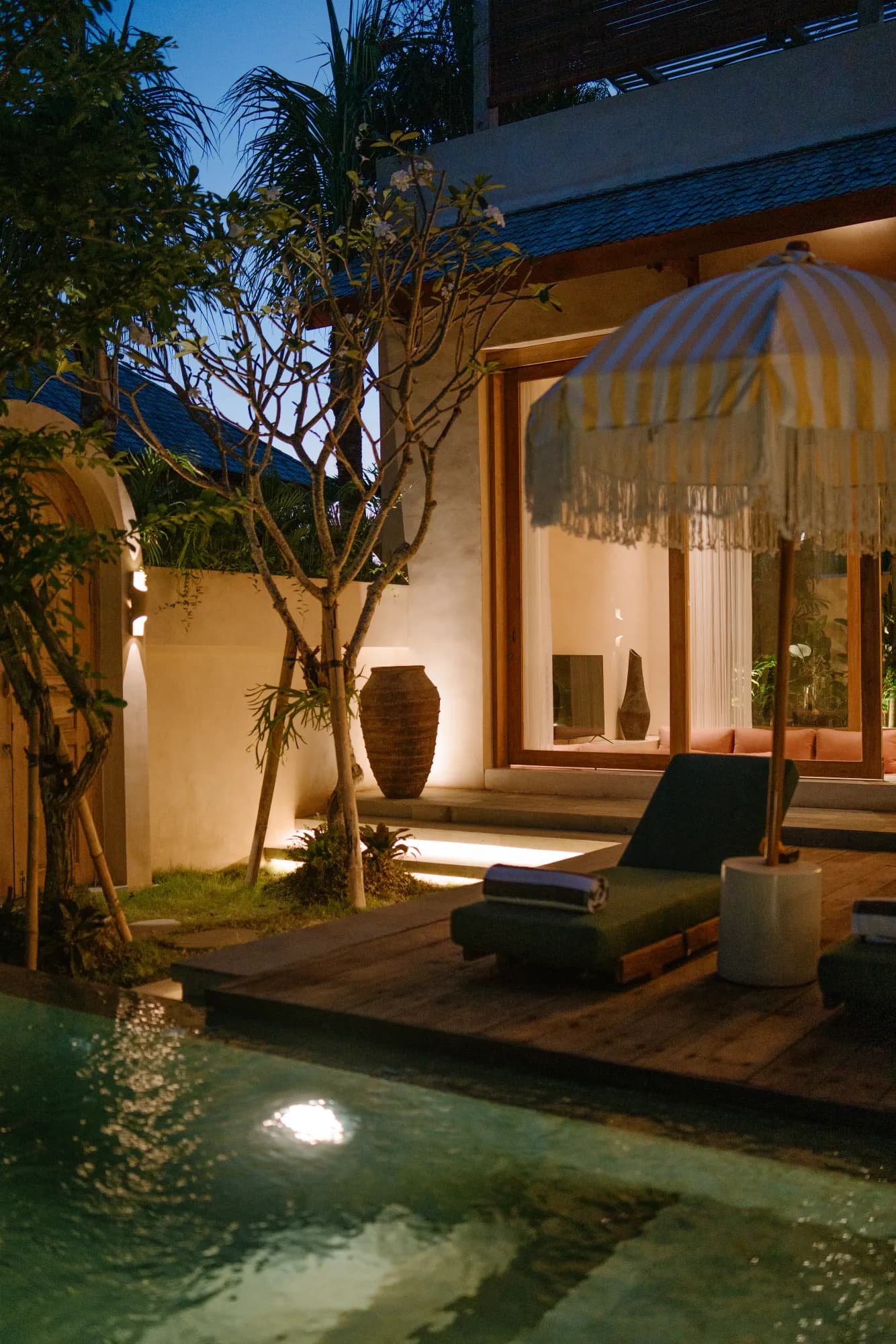 Terrace lit at night with garden and villa