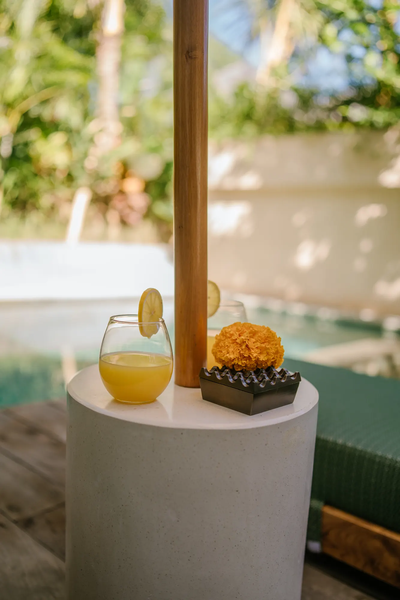 Dining table with striped umbrella and pool view