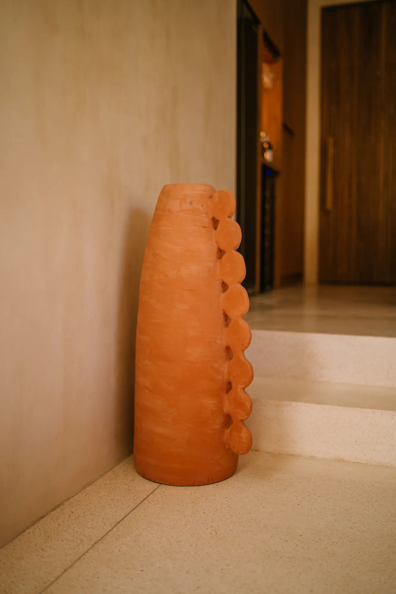 Sculptural terracotta piece in minimalist interior hallway