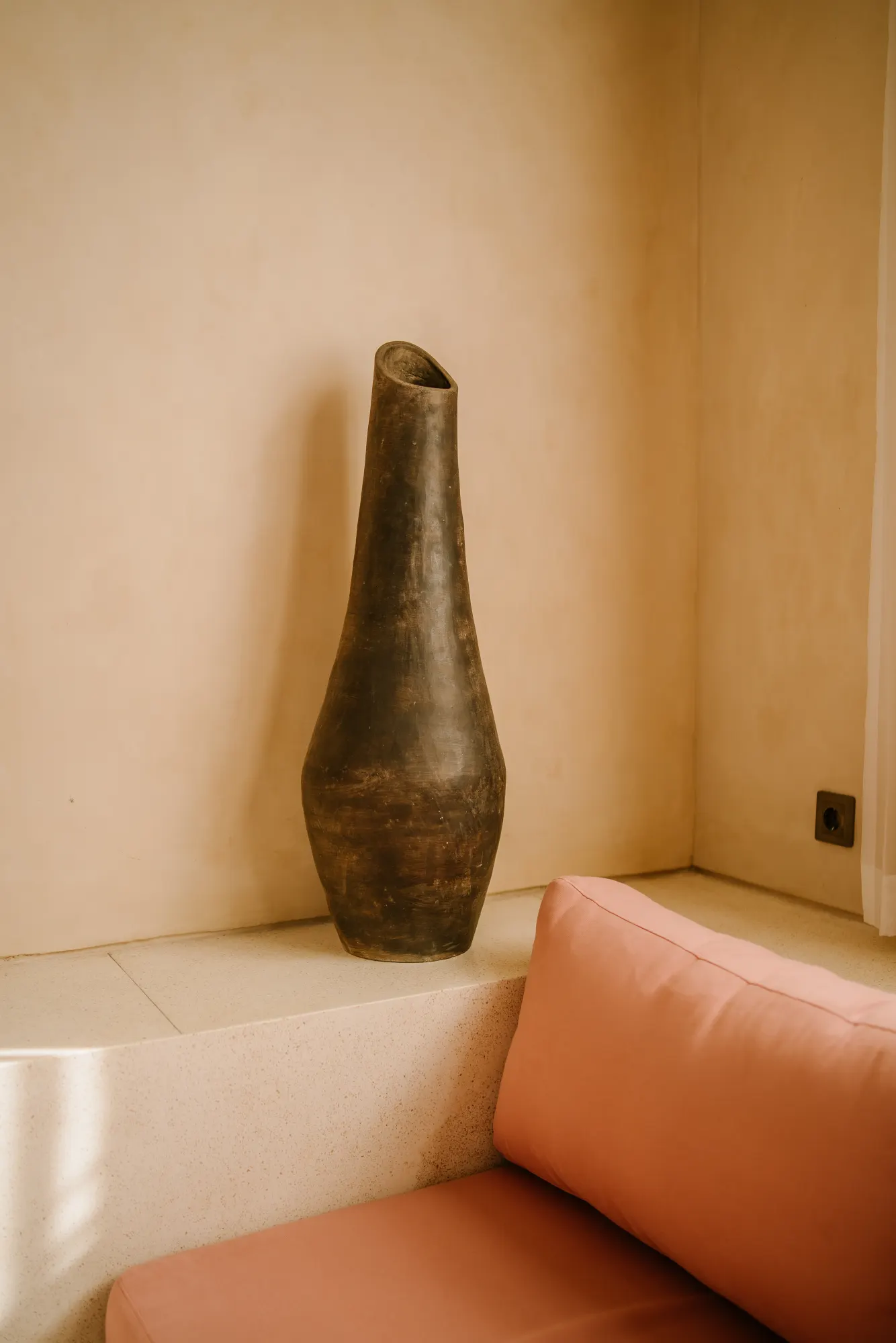 Sculptural vessel on terrazzo floor in minimalist interior space