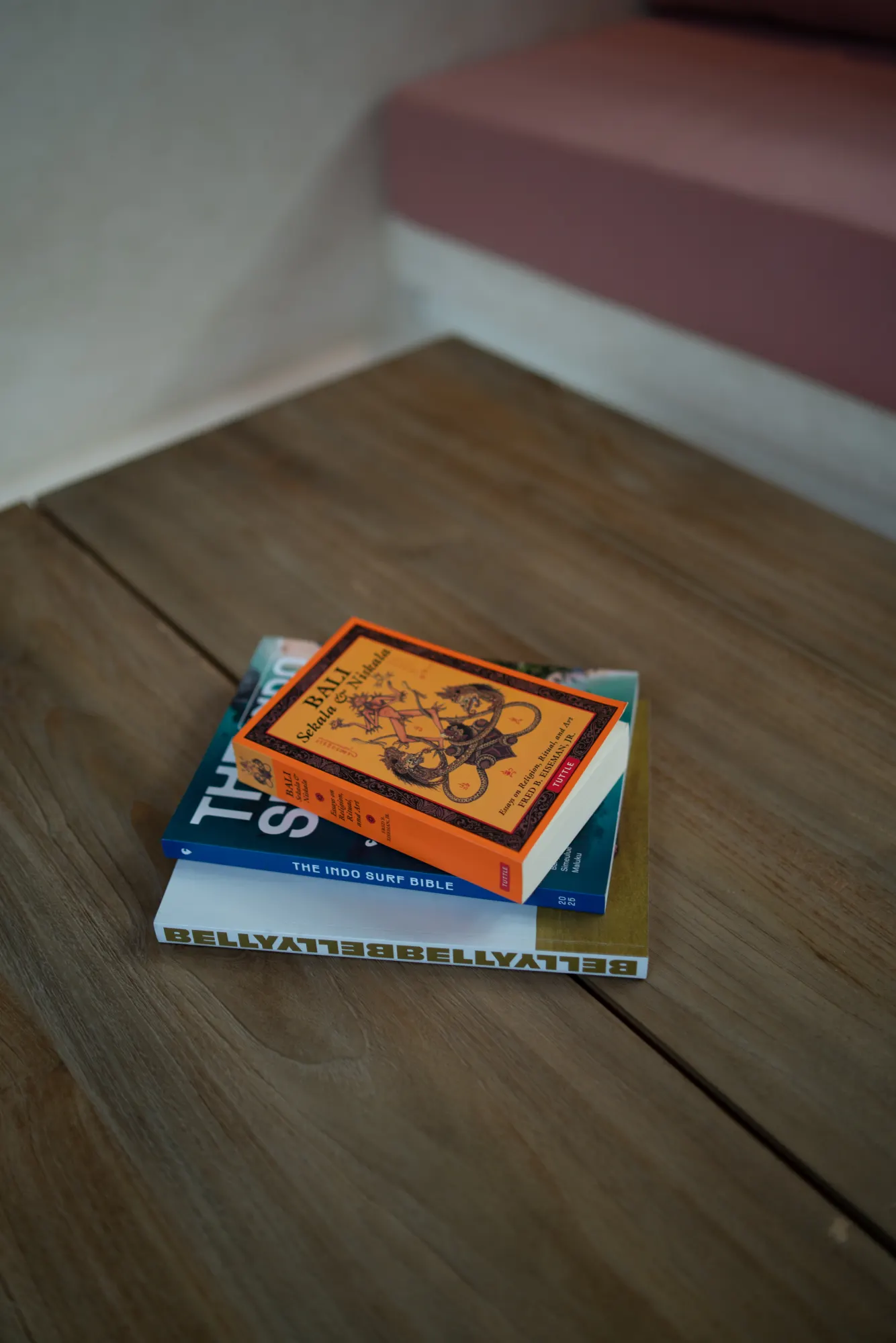 Stack of decorative books on natural wood surface indoors