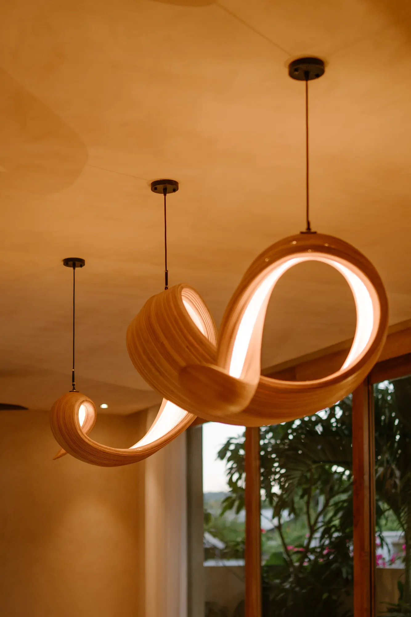 Row of sculptural wooden pendant lights overhead