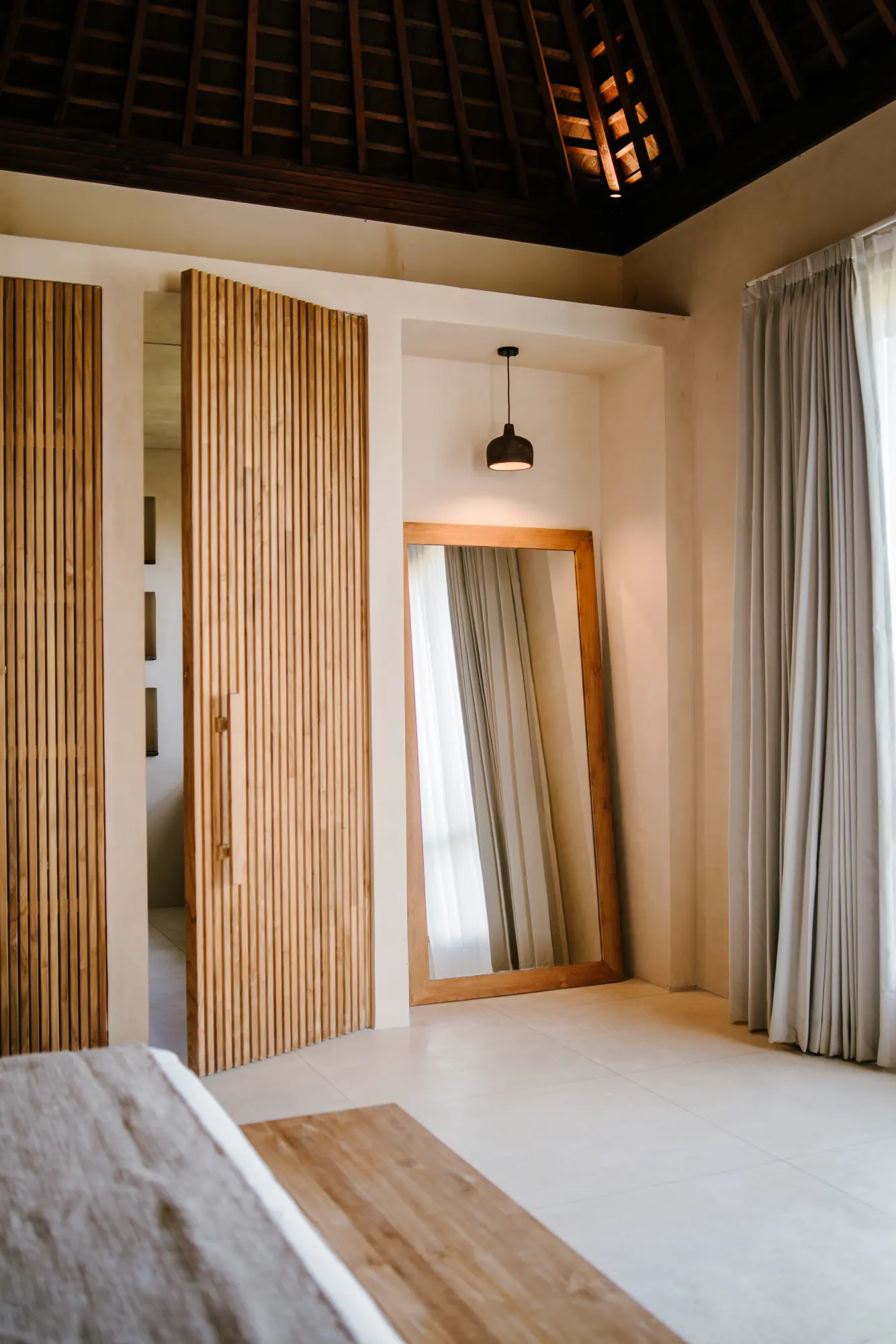 Bedroom with mirror, wardrobe, and hanging pendant light