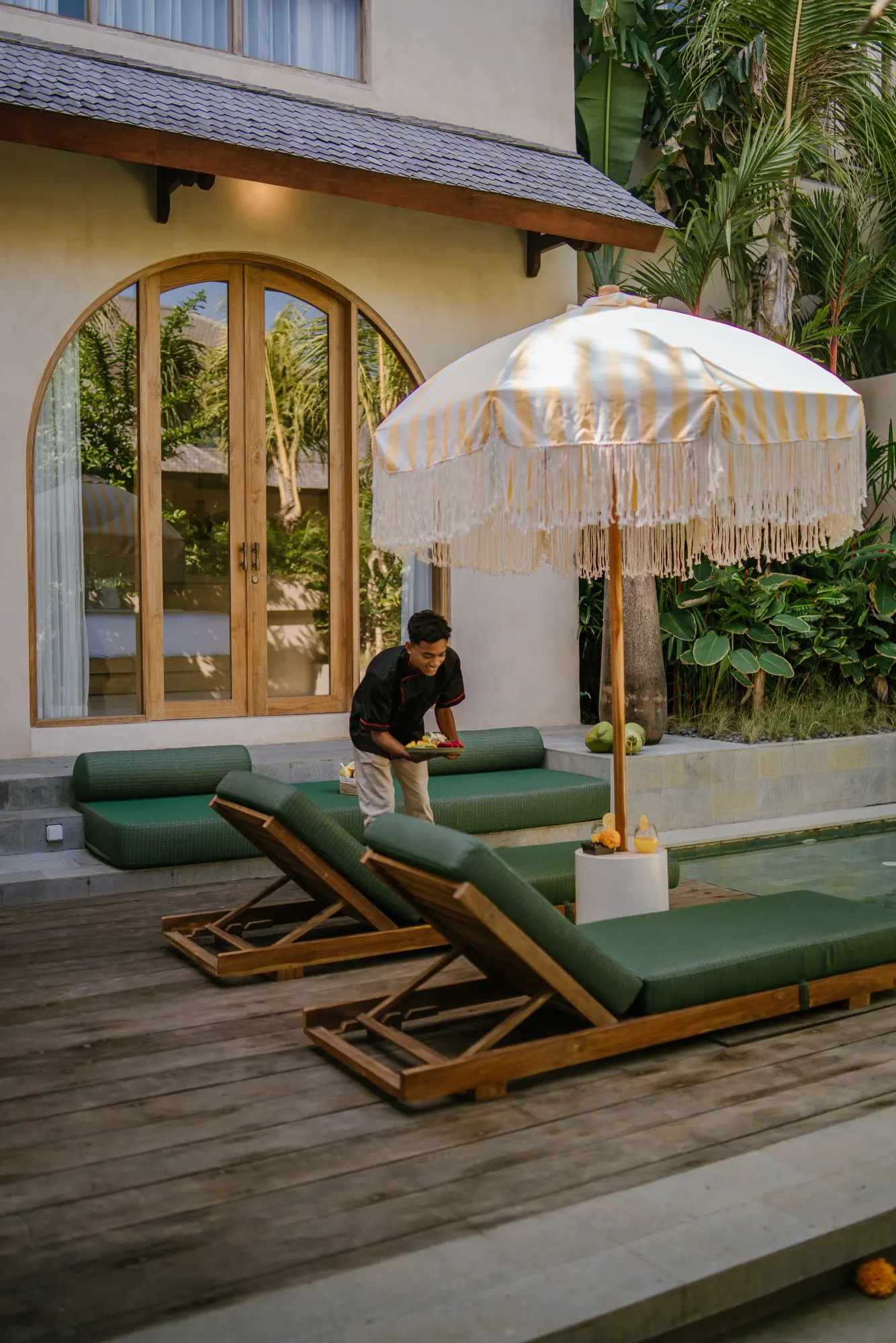 Poolside lounge with umbrella, guest relaxing